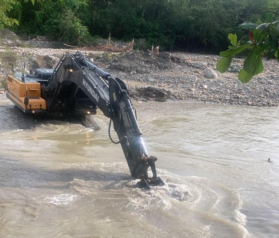 Retroexcavadora realizando trabajos en la obra de toma del acueducto de Imbert